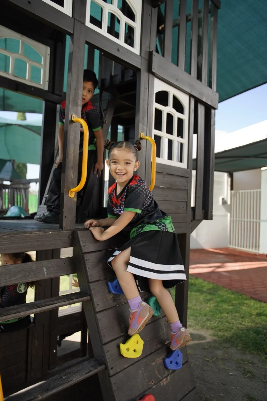 Niña de preescolar del CRB escalando en el área de juegos